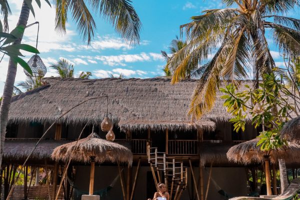 Asia Inolvidable: Claves para un Viaje de Alta Gama Una mujer relajándose en una piscina con vistas a palmeras, representando un viaje de alta gama en Asia.
