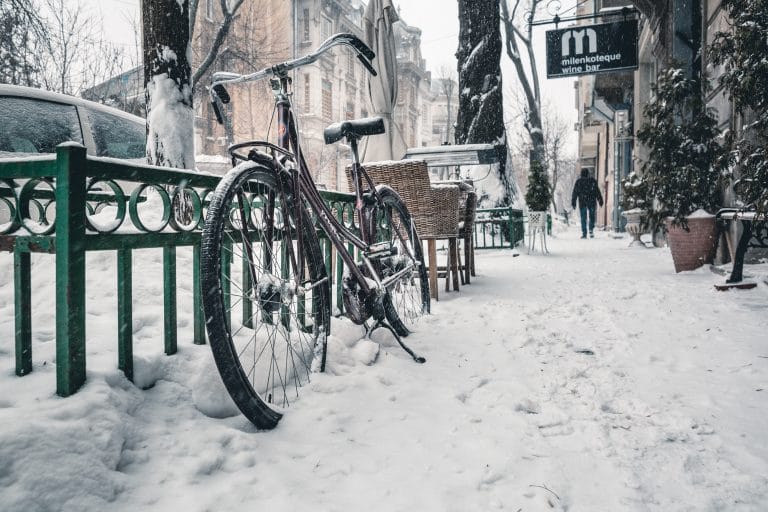 Una bicicleta apoyada en una calle cubierta de nieve, ilustrando la belleza de un destino ideal para disfrutar del invierno.