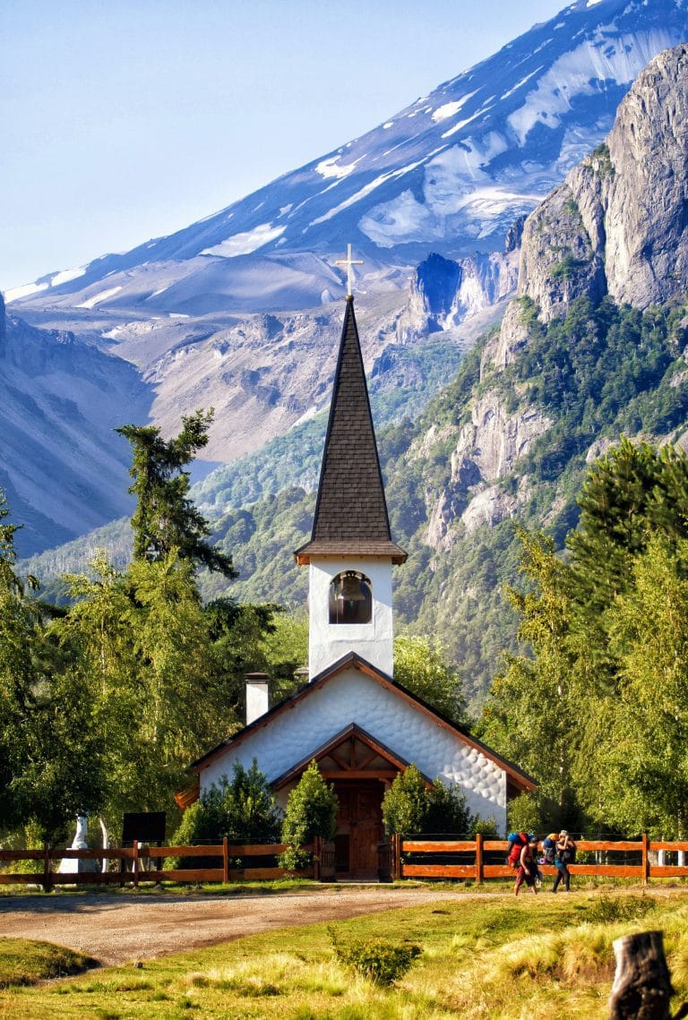 Iglesia solitaria entre las montañas de Bariloche que ilustra el trekking en Argebtina