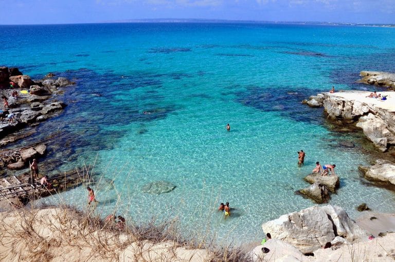Pequeña cala de aguas turquesas entre rocas, representando el último paraíso del Mediterráneo en Formentera.