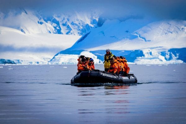 Una vista panorámica de un crucero de expedición de lujo navegando entre imponentes icebergs en la Antártida.