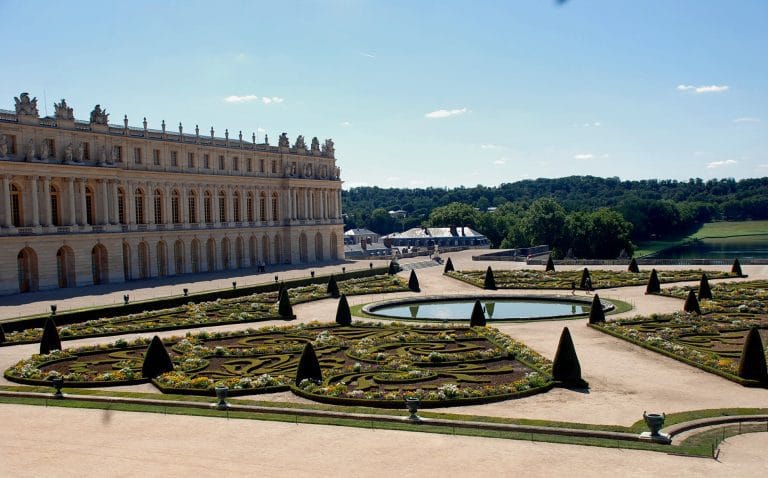 Vista parcial de un castillo francés y sus jardines, representando los castillos majestuosos y la historia de Europa.