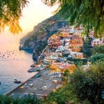 El Secreto de la Costa Amalfitana: Viaje de Lujo más allá de Positano Panorámica de Positano, Italia, un pueblo colorido en el acantilado, con vistas al mar y la playa.