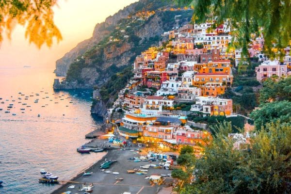 El Secreto de la Costa Amalfitana: Viaje de Lujo más allá de Positano Panorámica de Positano, Italia, un pueblo colorido en el acantilado, con vistas al mar y la playa.