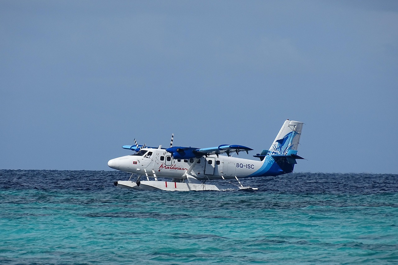 Hidroavión de lujo aterrizando en aguas turquesas, símbolo del acceso exclusivo a destinos remotos con servicio de mayordomía.