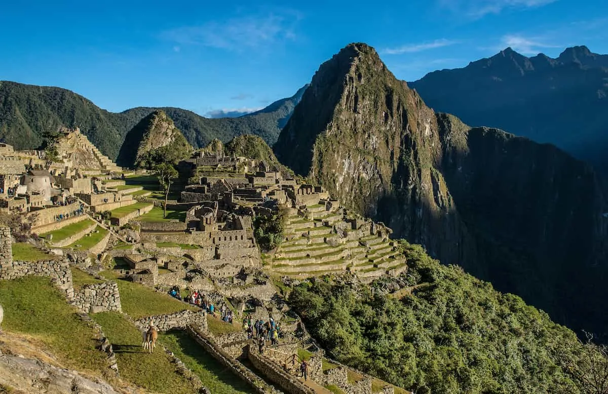 Vista panorámica de Machu Picchu al amanecer con montañas andinas al fondo, sin turistas, sin texto ni logotipos