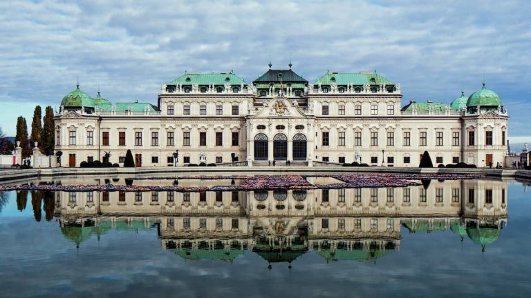 Vista frontal del Palacio Belvedere desde los jardines simétricos en Viena, representando viajes de lujo.