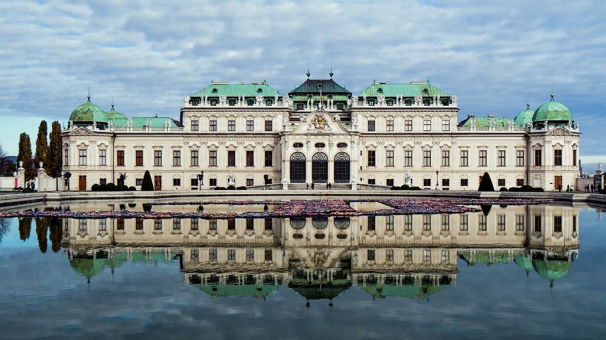 Vista frontal del Palacio Belvedere desde los jardines simétricos en Viena, representando viajes de lujo.