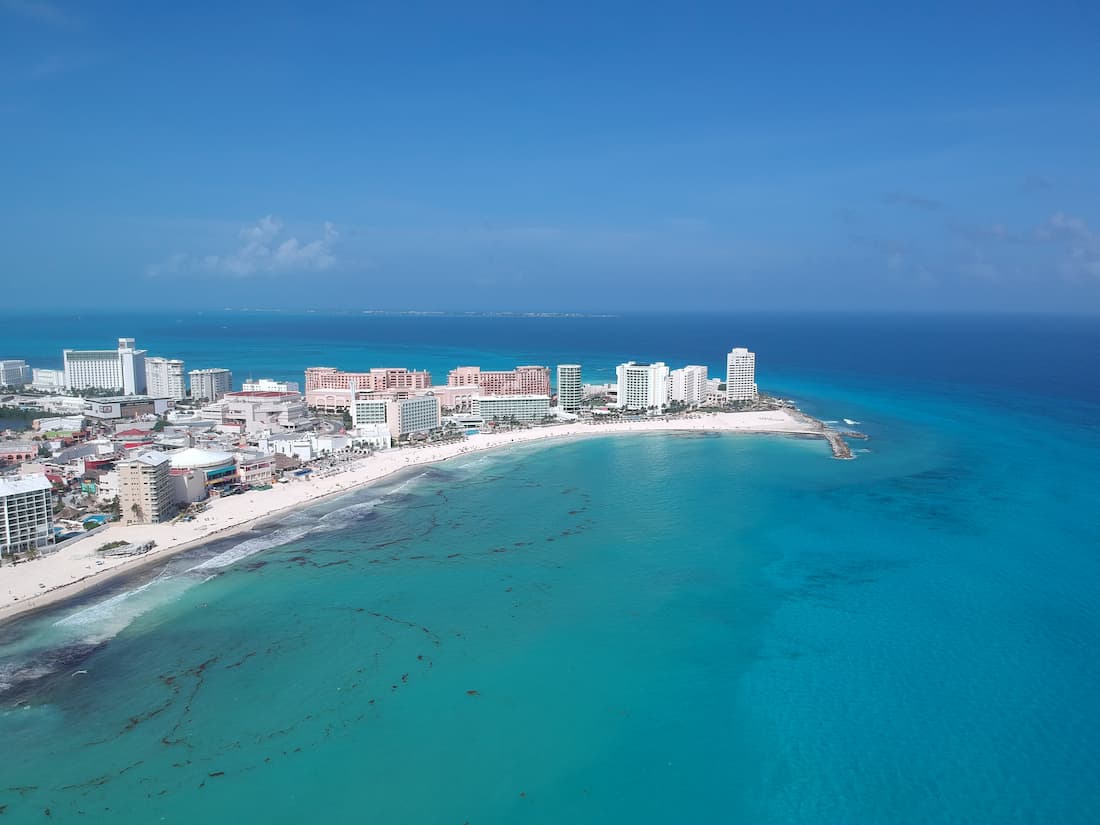 Panorámica aérea de la Zona Hotelera de Cancún con resorts de lujo y mar turquesa en un viaje de lujo a Riviera Maya