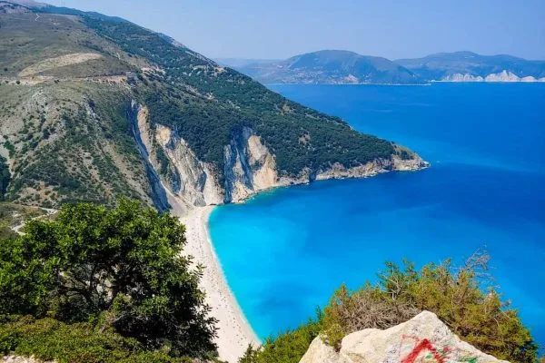 Vista aérea parcial de la escarpada costa de la isla de Cefalonia con aguas de un azul irreal.