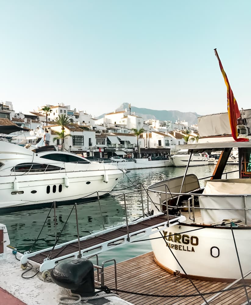Yates de lujo en Puerto Banús con letrero MARBELLA visible en uno de ellos