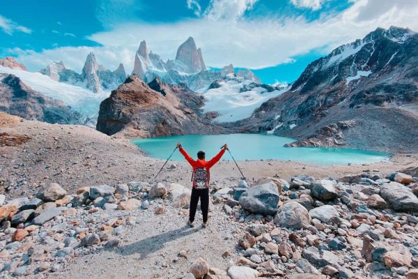 Hombre con abrigo frente a un lago andino durante un viaje de lujo a Argentina