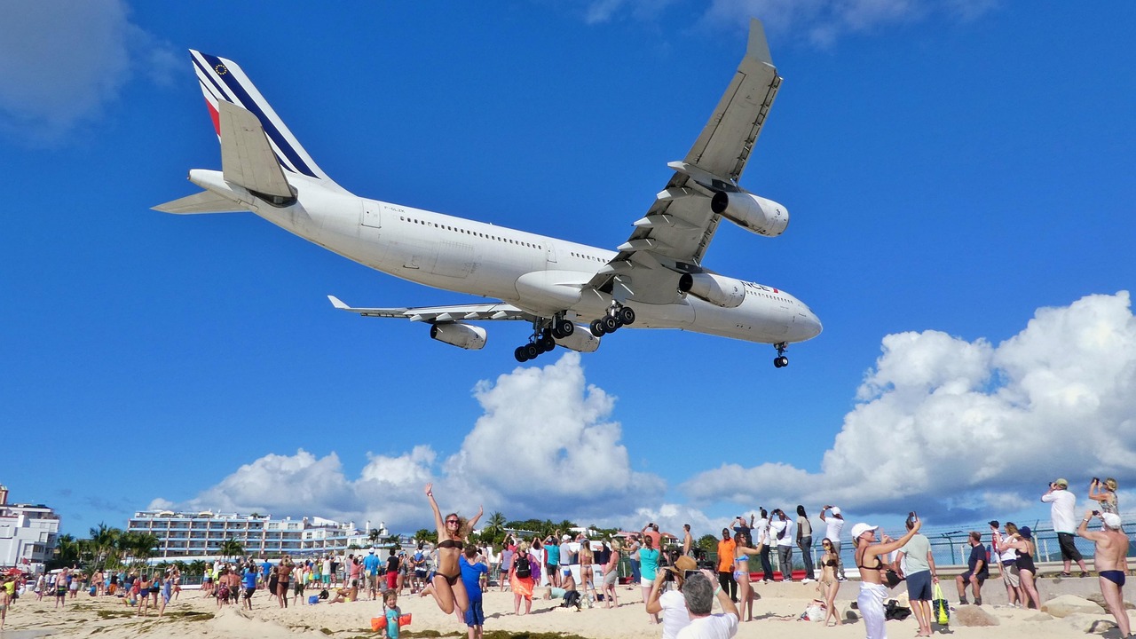 Maho Beach - Espectáculo Aéreo Caribeño Avión aterrizando sobre Maho Beach Saint Martin Caribe con playa turistas