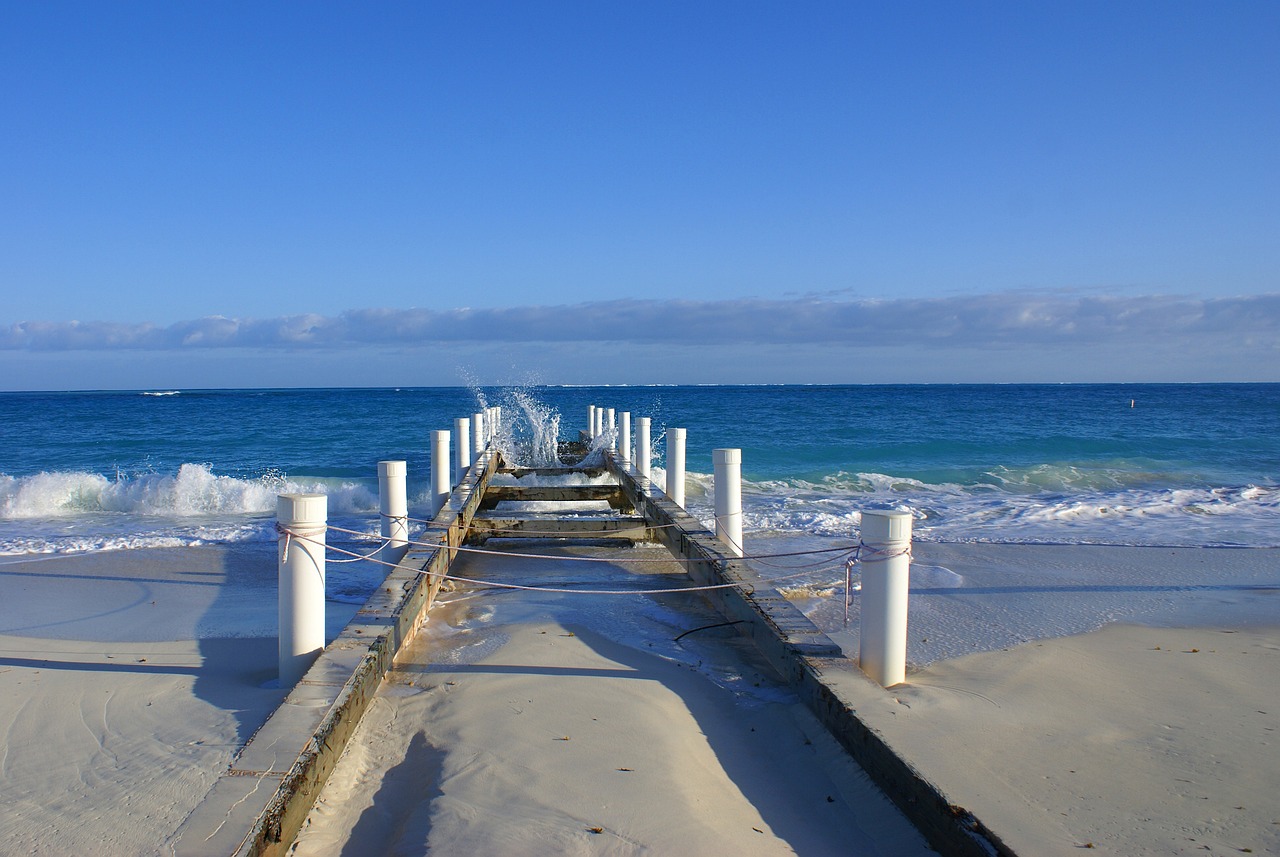 Muelle cemento viejo entrando mar azul intenso olas blancas Islas Turcas y Caicos