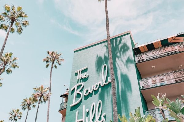 Letrero del hotel The Beverly Hills entre palmeras tropicales, icono de Los Ángeles