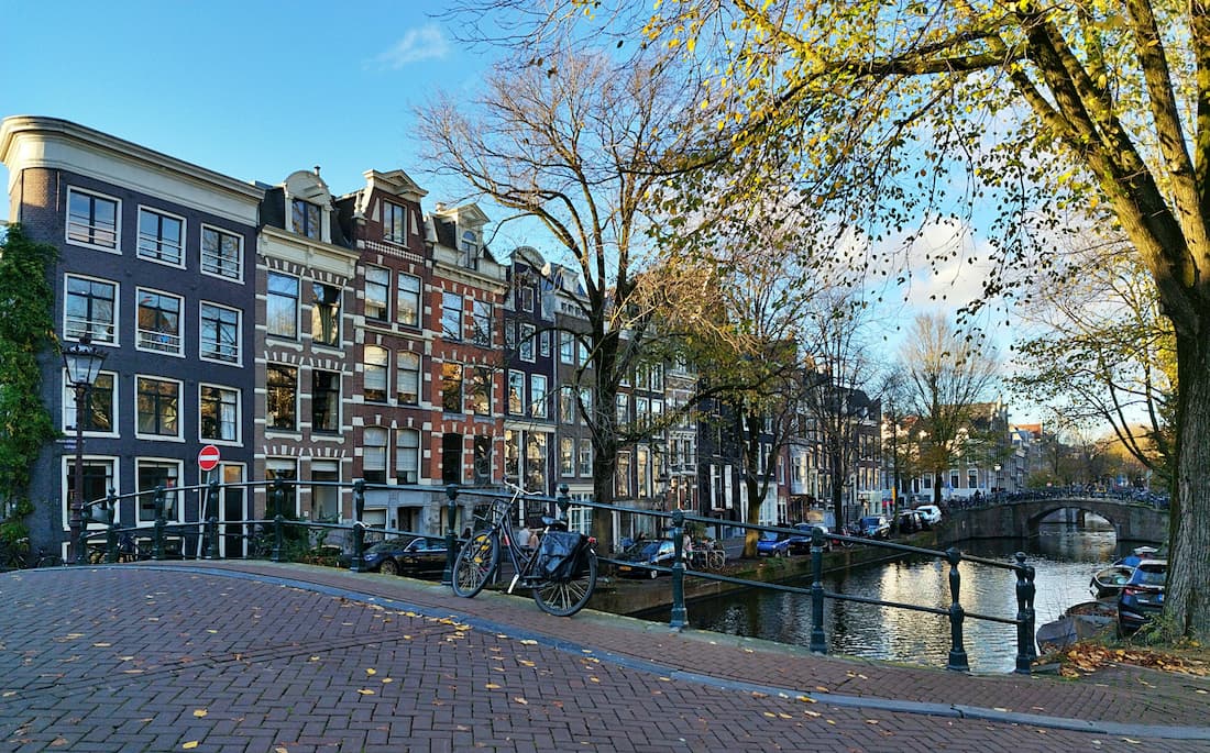 Canal del barrio del Jordaan en Ámsterdam con casas del siglo XVII, bicicletas aparcadas y un puente de hierro