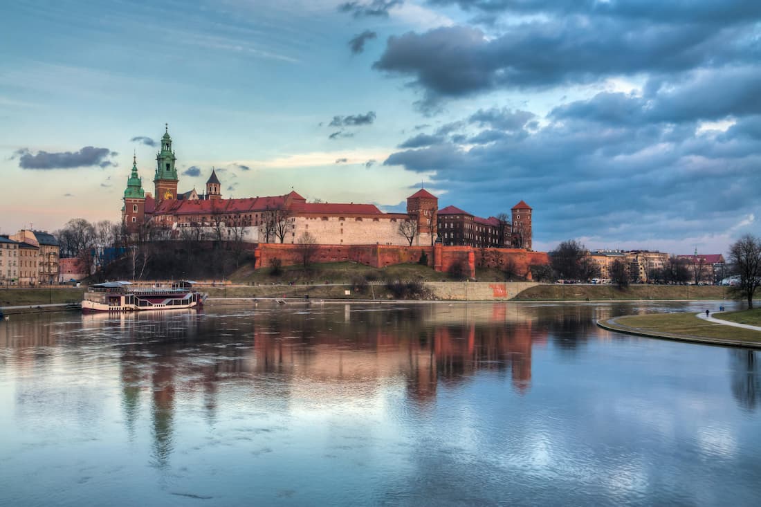Vista panorámica del Castillo Real de Wawel sobre el río Vístula al atardecer en Cracovia