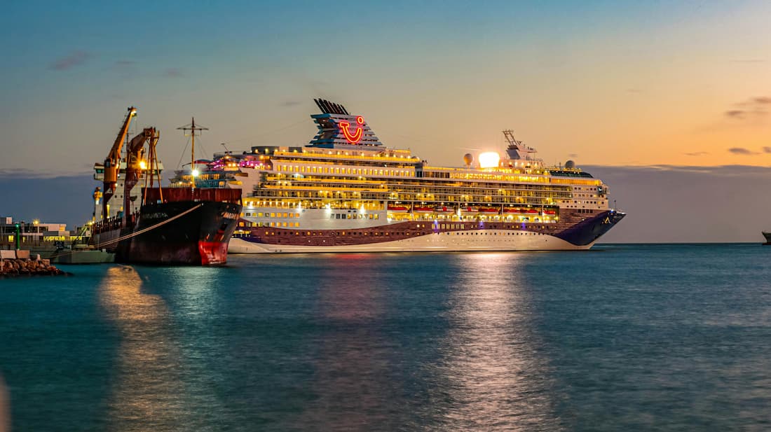 Crucero TUI al atardecer en el puerto de Málaga listo para zarpar en travesía de lujo