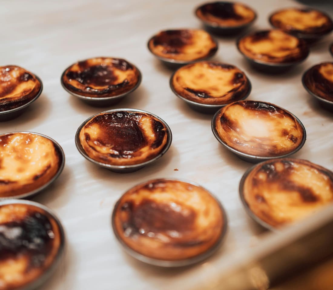 Bandeja de pasteles de nata recién horneados en una pastelería de Belém en Lisboa