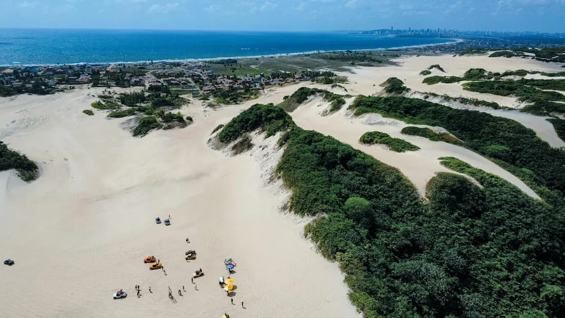 Dunas doradas del Parque Ecológico de Genipabu con laguna de agua dulce verde esmeralda en Natal Brasil