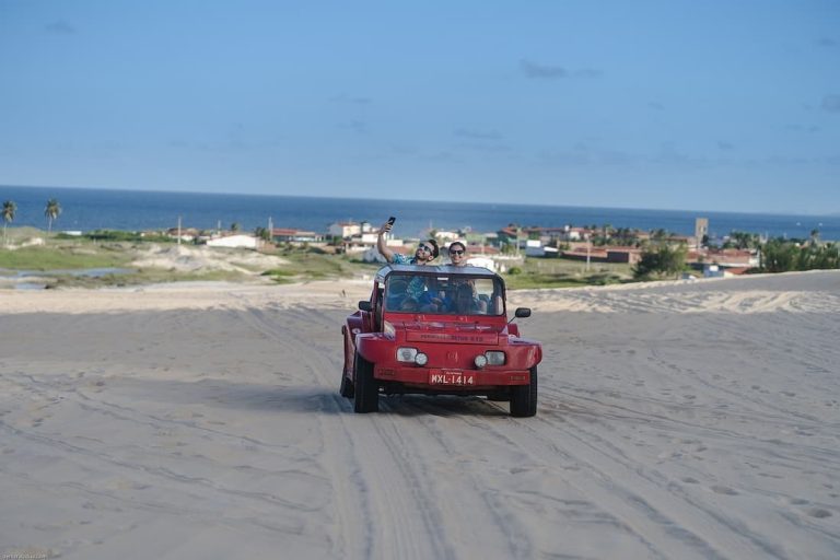 Mehari rojo sobre las dunas de Natal Brasil con el mar Atlántico al fondo
