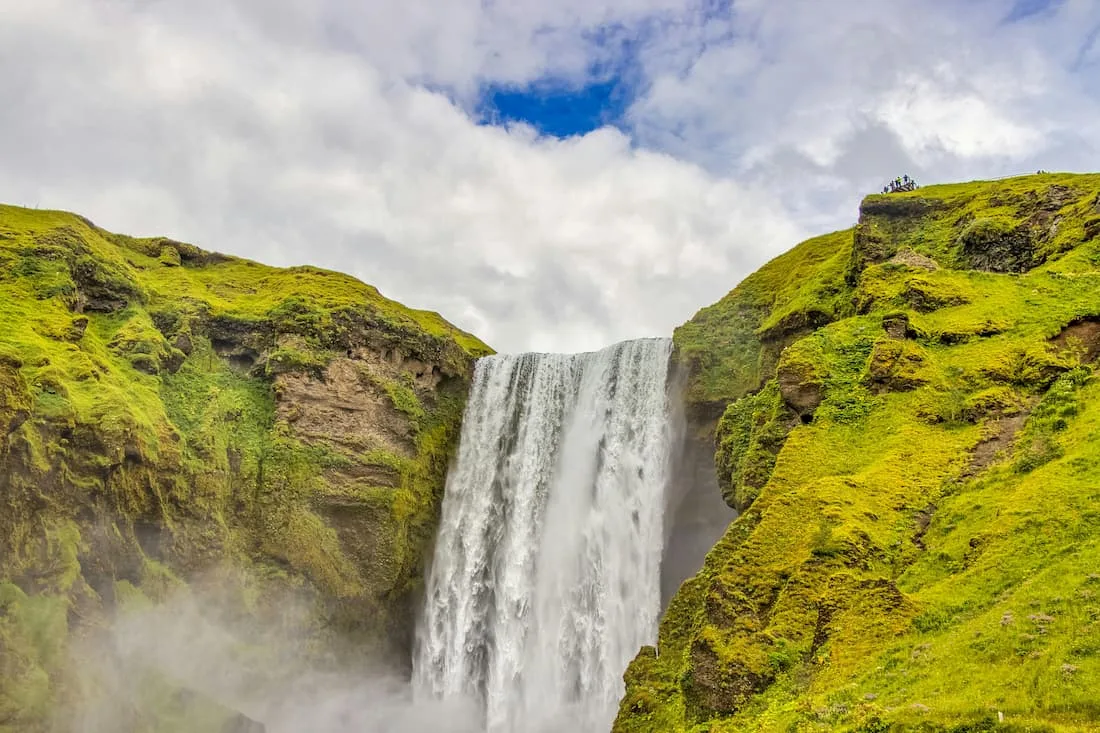 Cascada Skógafoss en la Costa Sur de Islandia con su cortina de agua y el arcoíris permanente en excursión desde Reikiavik