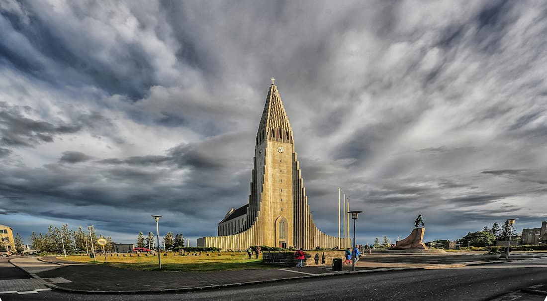 Fachada de la Iglesia Hallgrímskirkja en Reikiavik con su diseño de columnas basálticas de hormigón blanco bajo el cielo azul