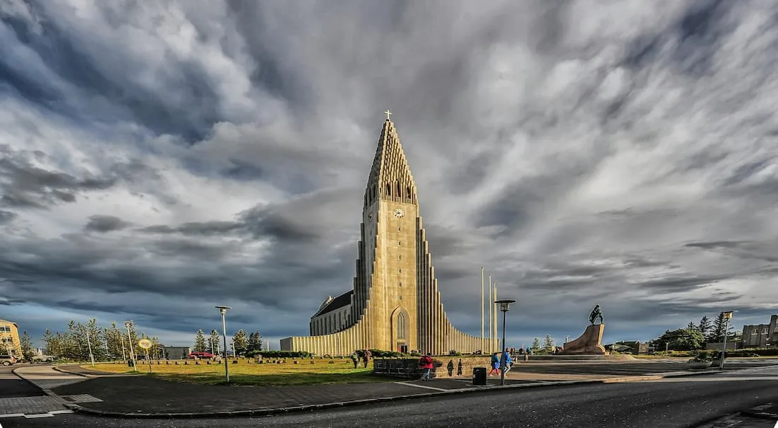 Fachada de la Iglesia Hallgrímskirkja en Reikiavik con su diseño de columnas basálticas de hormigón blanco bajo el cielo azul