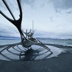 Monumento del Viajero del Sol (Sun Voyager) en Reikiavik con el mar y las montañas al fondo