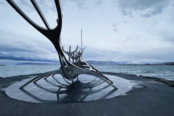 Monumento del Viajero del Sol (Sun Voyager) en Reikiavik con el mar y las montañas al fondo