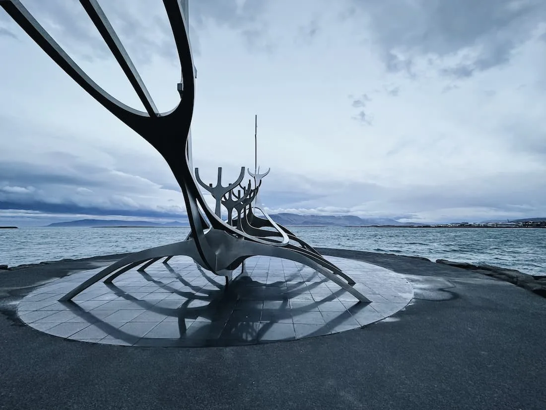 Monumento del Viajero del Sol (Sun Voyager) en Reikiavik con el mar y las montañas al fondo