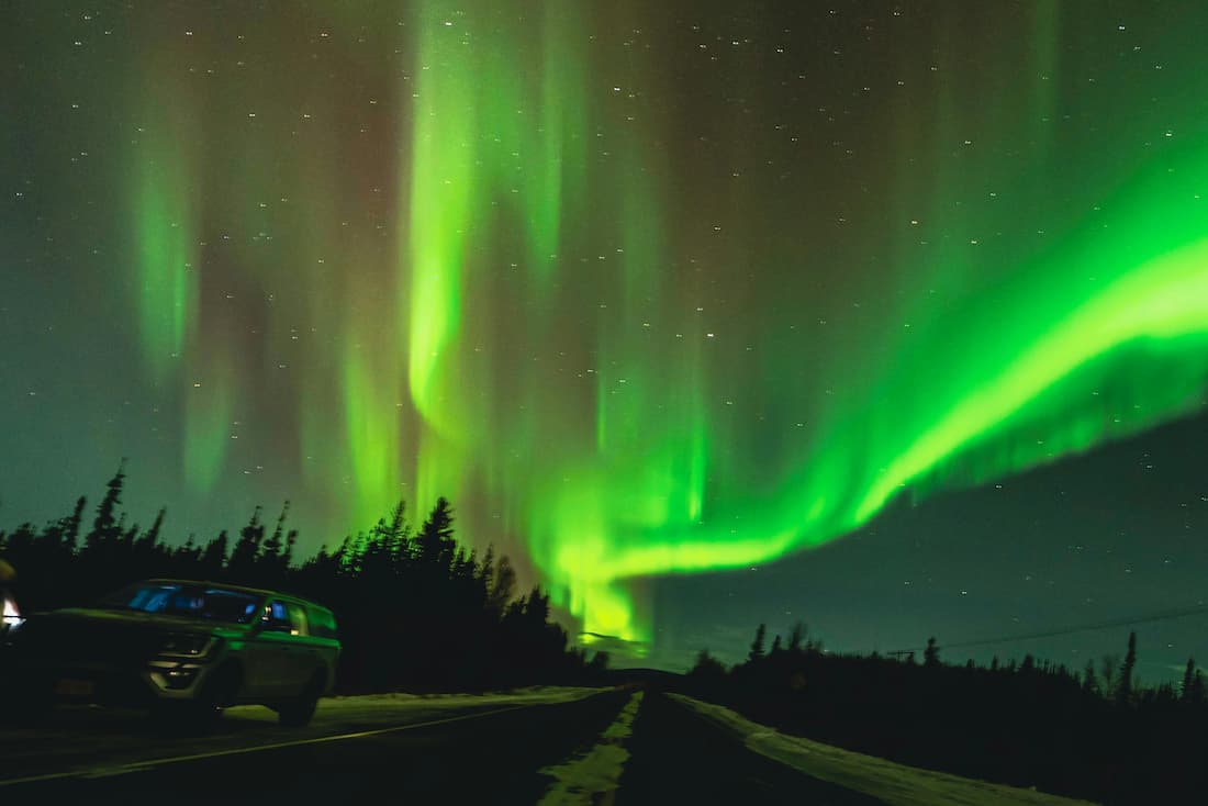 Aurora boreal en Fairbanks Alaska — las luces verdes sobre el bosque nevado del interior alaskeño Aurora boreal verde sobre un bosque de pinos nevados en Fairbanks, Alaska, en noche de invierno