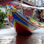 Barca de colores llevando turistas por un canal khlong en Bangkok