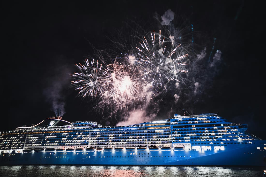 Dos cruceros de lujo amarrados en el puerto de Barcelona de noche con reflejos en el agua mediterránea