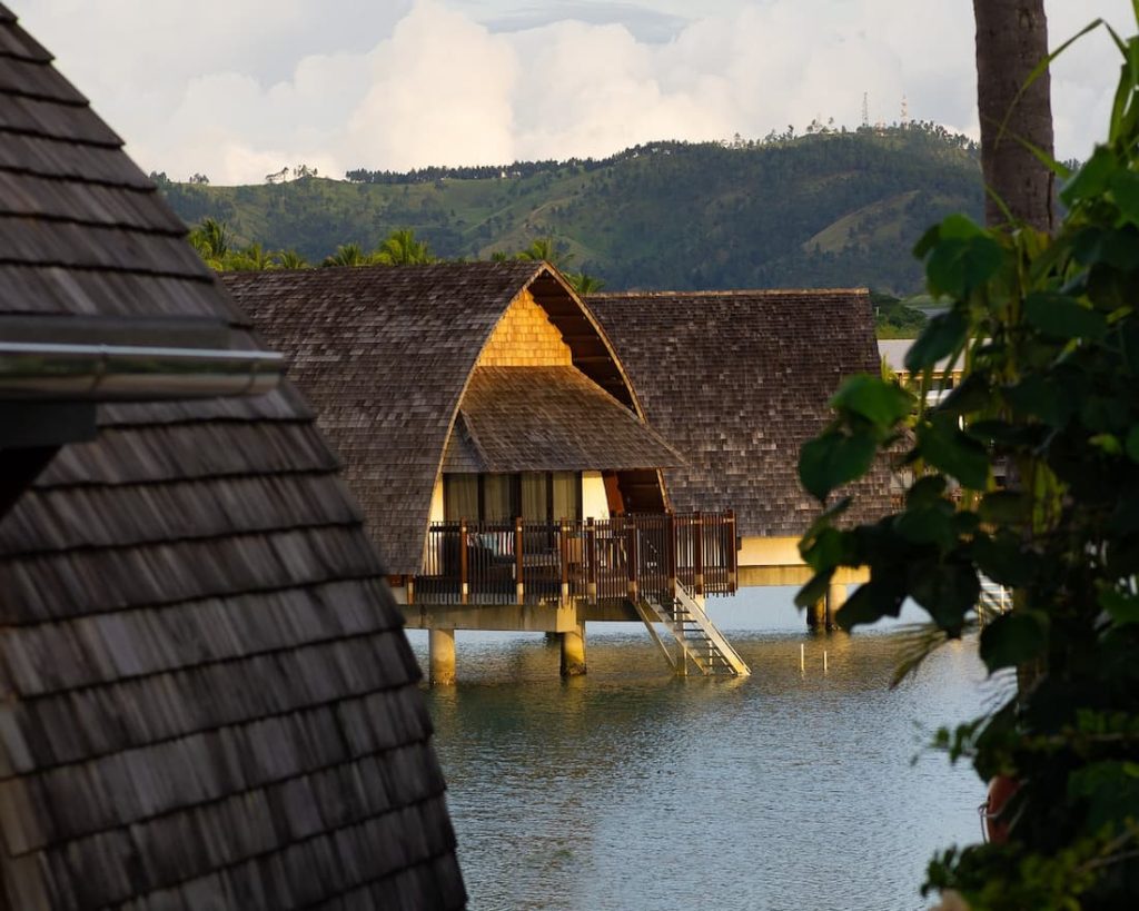 Bungalows sobre pilotis en el mar al atardecer en un resort de Fiyi en el Pacífico Sur