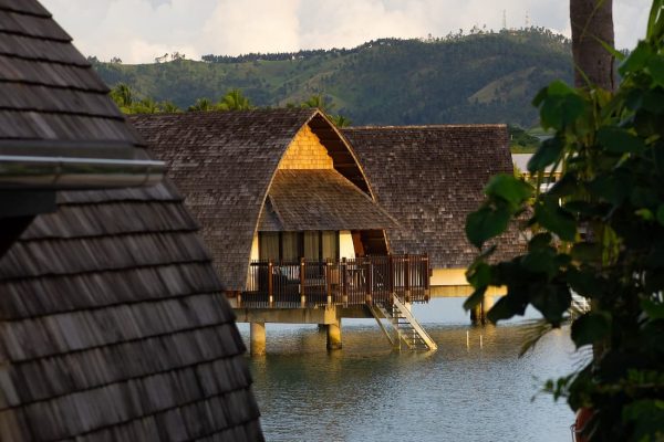 Bungalows sobre pilotis en el mar al atardecer en un resort de Fiyi en el Pacífico Sur