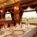 Interior del vagón restaurante del Maharajas' Express con decoración real india, mesas con mantelería de lujo e iluminación cálida