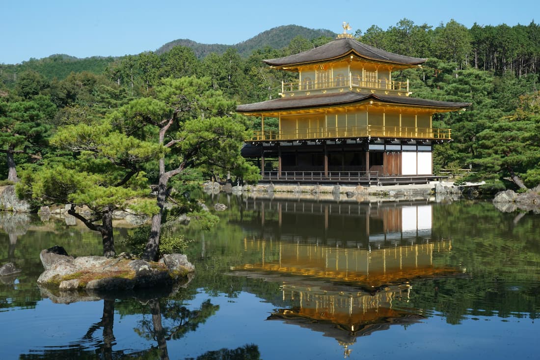 Vista serena del Pabellón Dorado Kinkaku-ji reflejado en el estanque tranquilo de Kioto, Japón