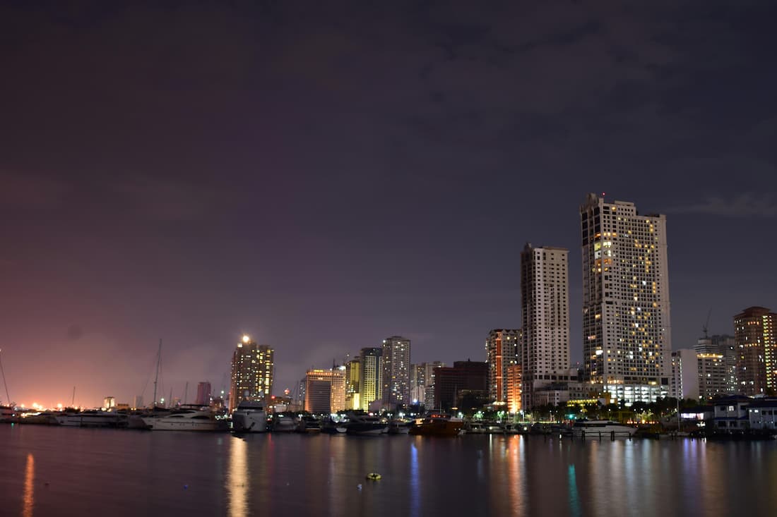 Atardecer sobre la Bahía de Manila desde el paseo marítimo del Roxas Boulevard con el cielo naranja