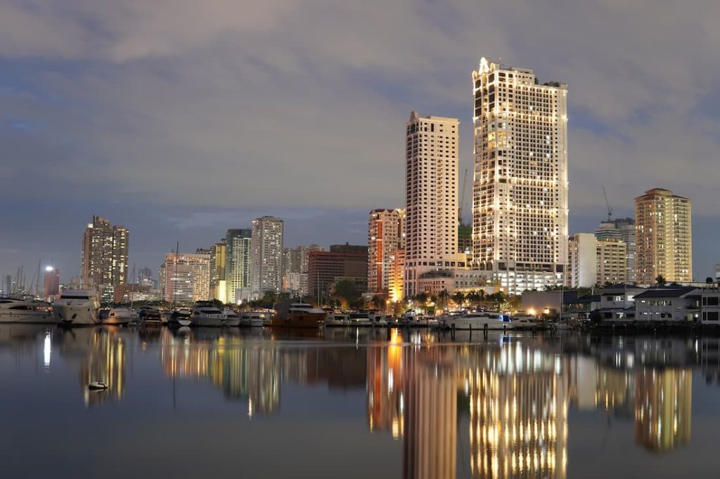 Vista panorámica nocturna de Manila desde el mar con el skyline iluminado de la ciudad