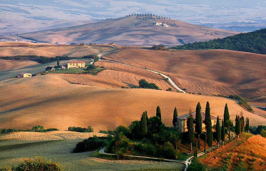 Luna de miel en Toscana — los viñedos del Val d'Orcia al atardecer, Patrimonio UNESCO Viñedos del Val d'Orcia en la Toscana al atardecer con villa y cipreses para luna de miel romántica