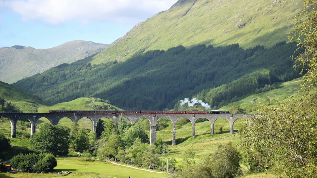 Viaducto de Glenfinnan Fort William Escocia tren Belmond Royal Scotsman Vista aérea del Viaducto de Glenfinnan en Fort William Escocia con el Belmond Royal Scotsman cruzando entre las Highlands