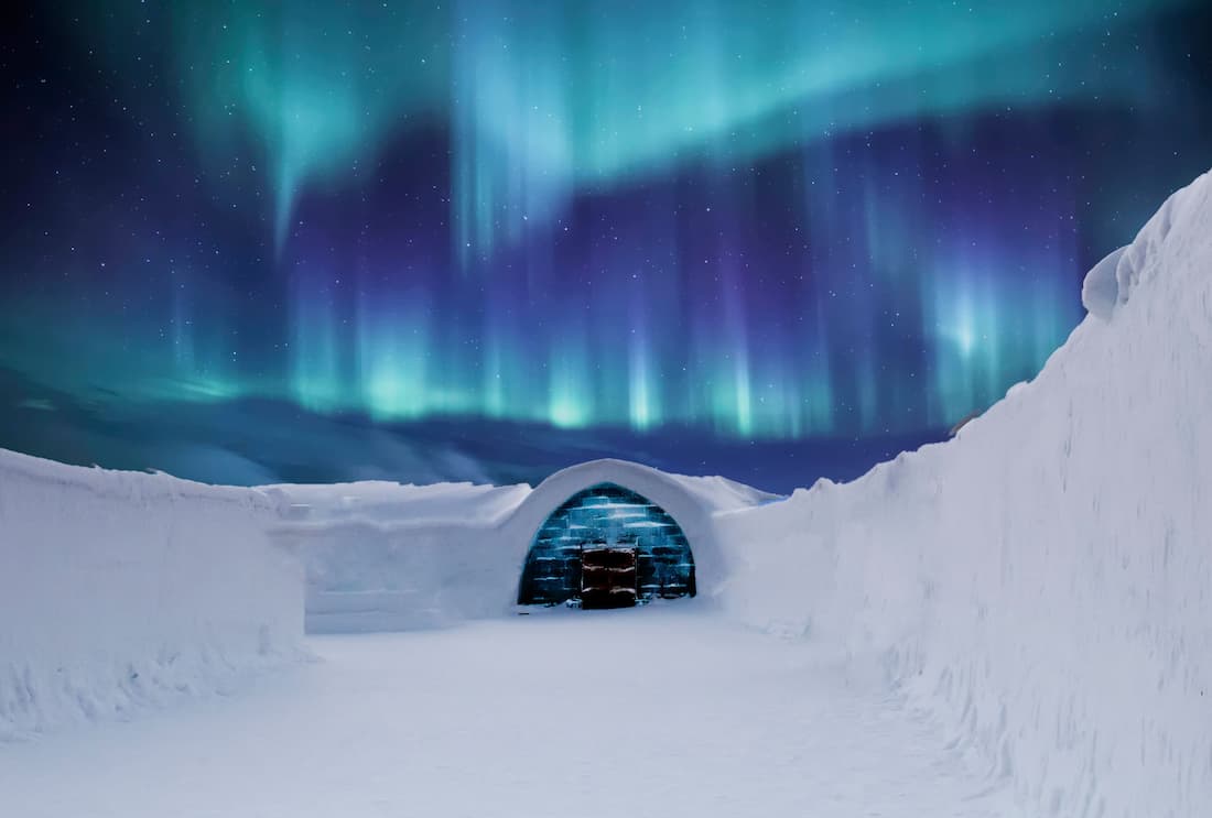 Cabaña de cristal en Laponia con aurora boreal en el cielo nocturno para luna de miel romántica