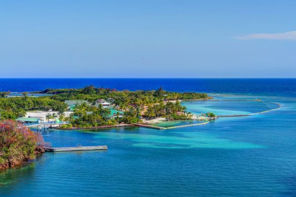 Vista panorámica de isla caribeña rodeada de aguas turquesas y azul intenso en las Islas de la Bahía Roatán Honduras