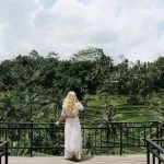 Mujer de espaldas con vestido blanco contemplando las terrazas de arroz de Tegalalang desde terraza con vistas en Ubud Bali