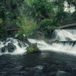Cascada de aguas blancas con puentes de madera rodeada de selva tropical en Costa Rica ecoturismo de lujo naturaleza