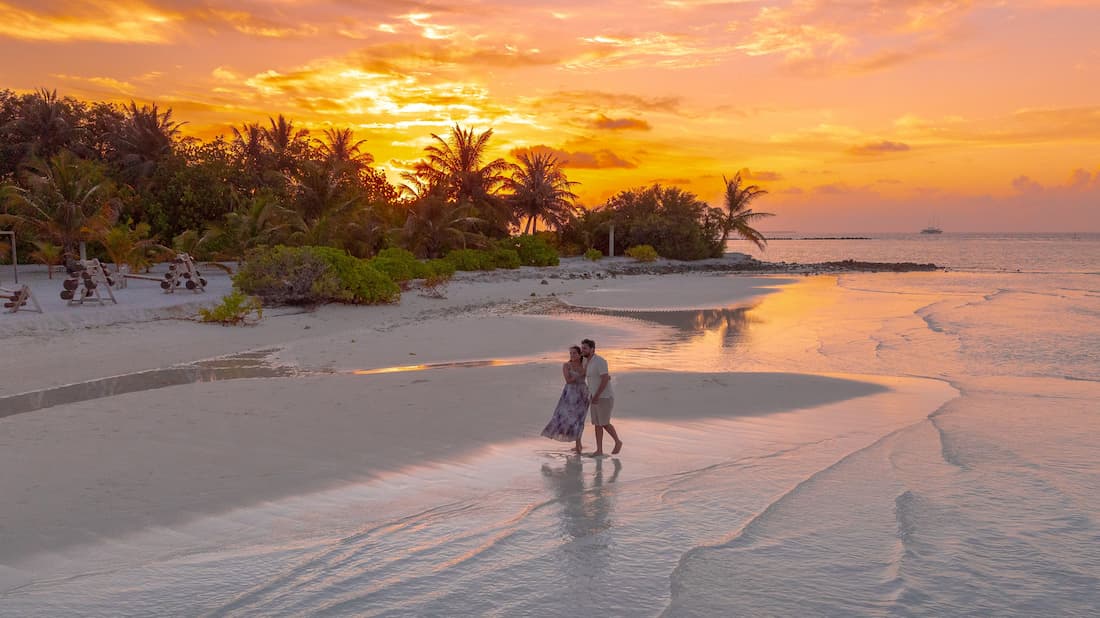 Pareja romántica al atardecer en playa del Caribe mexicano Riviera Maya luna de miel inolvidable