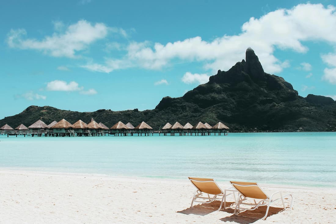 Overwater bungalow sobre laguna turquesa en Bora Bora Polinesia Francesa luna de miel de lujo pareja