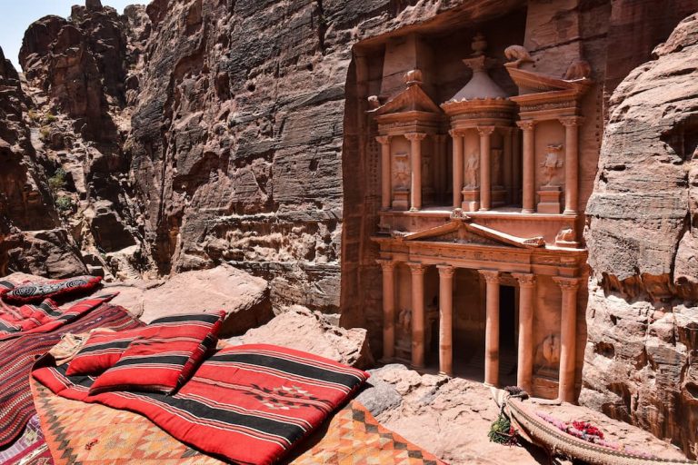El Tesoro de Petra en Jordania visto desde las alturas con alfombras beduinas en primer plano y arenisca rosa