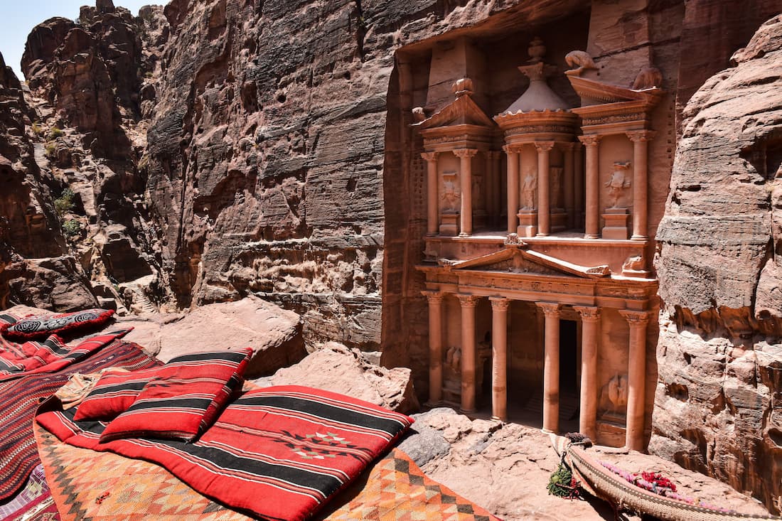 El Tesoro de Petra en Jordania visto desde las alturas con alfombras beduinas en primer plano y arenisca rosa